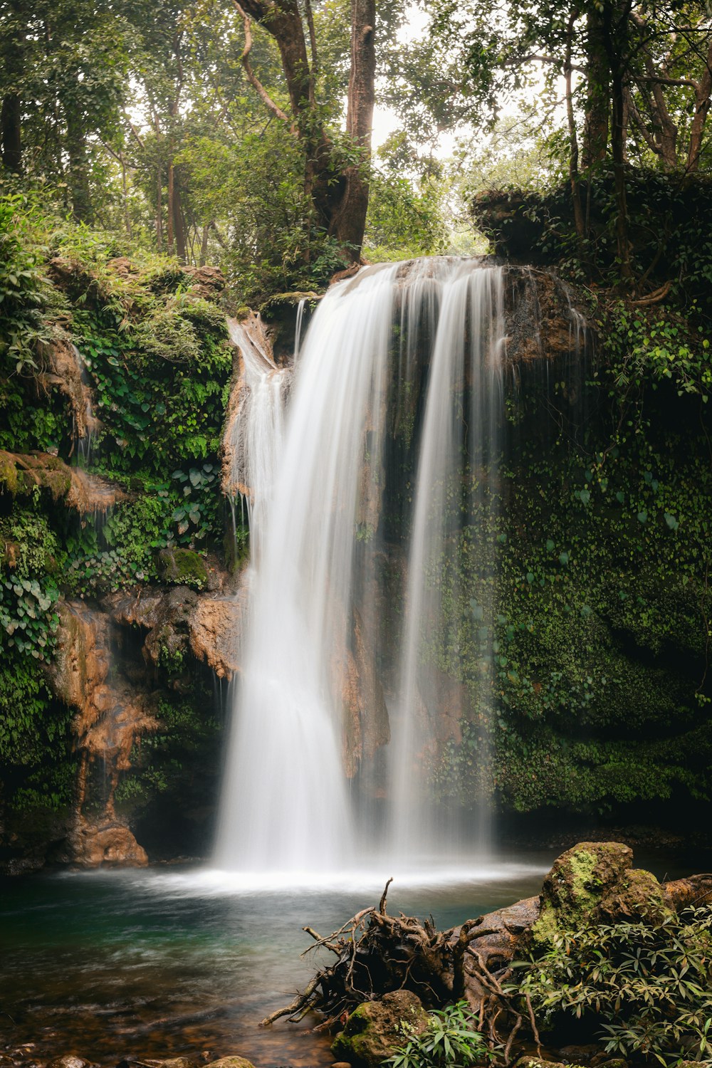 Waterfall flowing between green cliffs